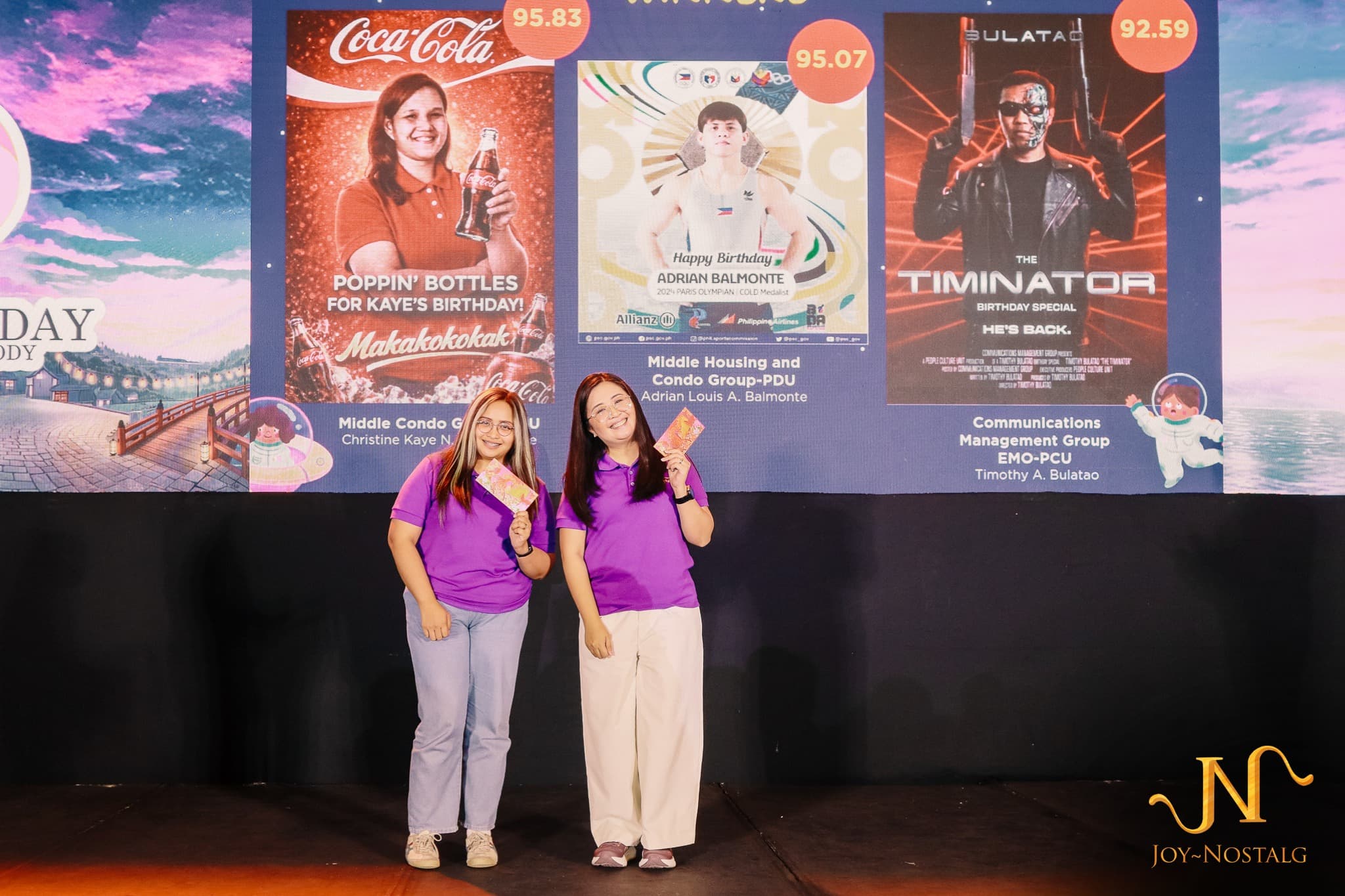 Two employees receiving recognition during a company program